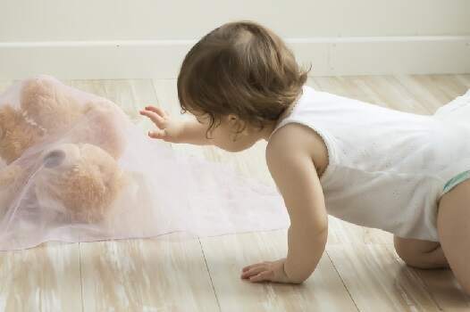 Bebé de 8 meses hace cucú-tras con su oso peluche